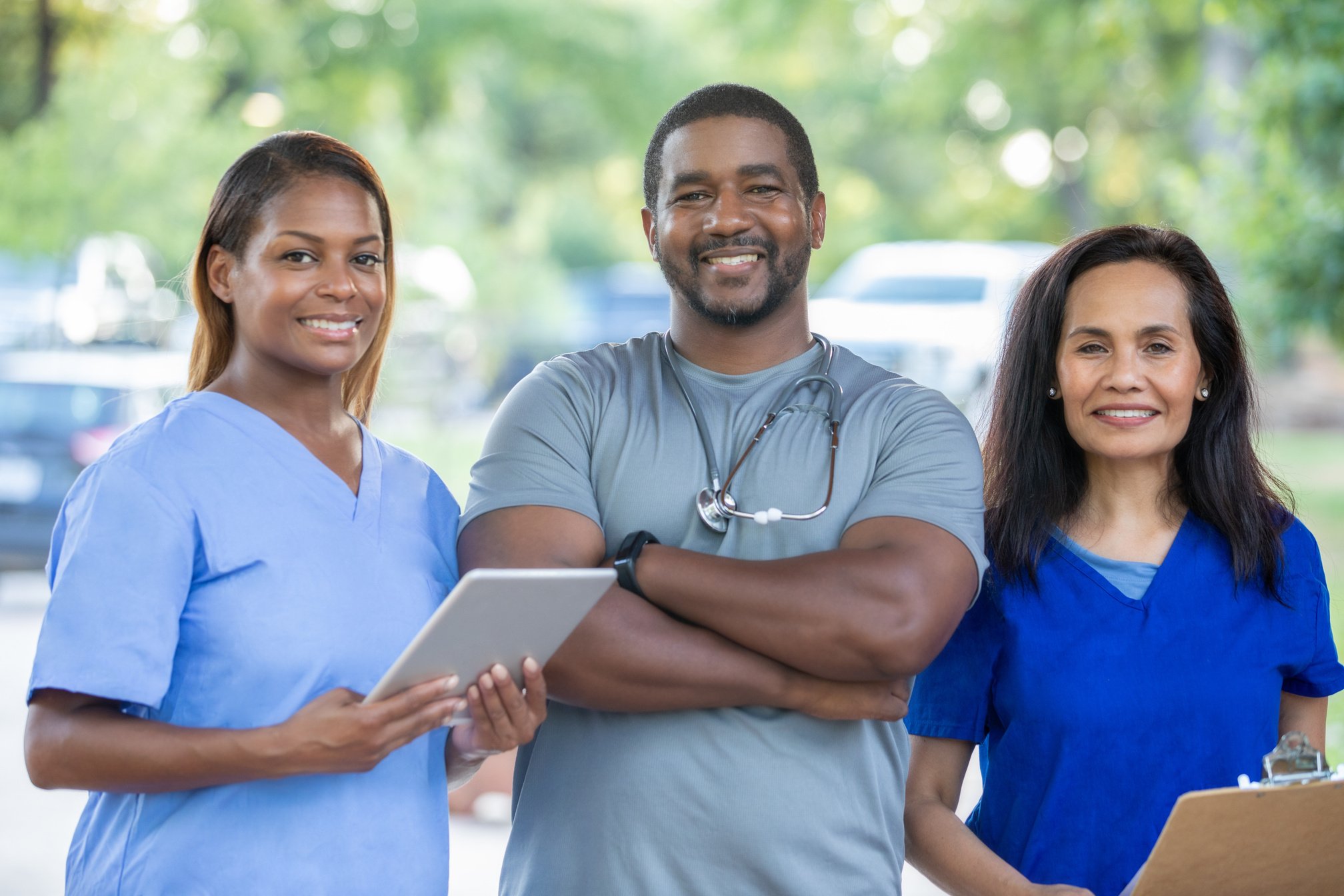 Diverse medical team of doctors and nurses smile during outdoor health fair for local community